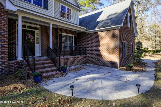 view of exterior entry featuring covered porch