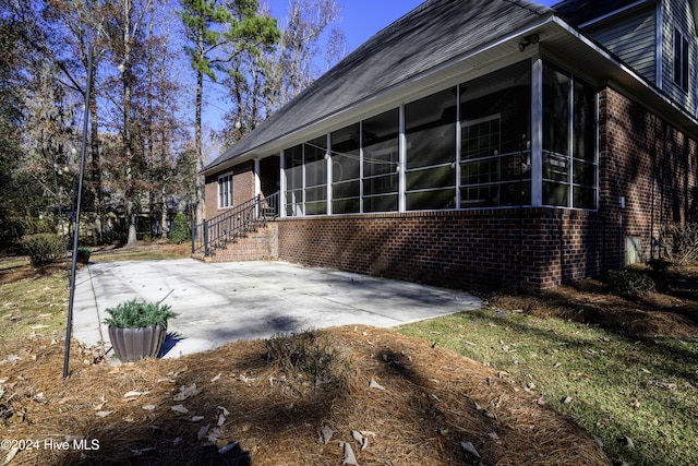 view of side of home with a patio area and a sunroom