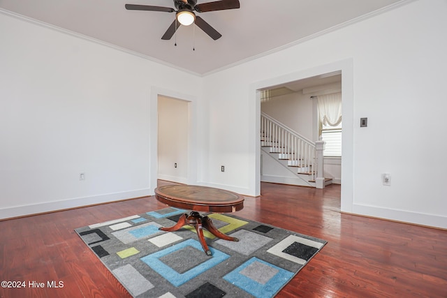 interior space with ceiling fan, dark hardwood / wood-style floors, and ornamental molding