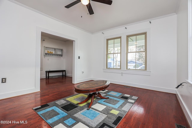 interior space featuring crown molding, ceiling fan, and dark wood-type flooring