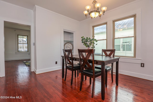 dining area with dark wood-type flooring, an inviting chandelier, a healthy amount of sunlight, and crown molding