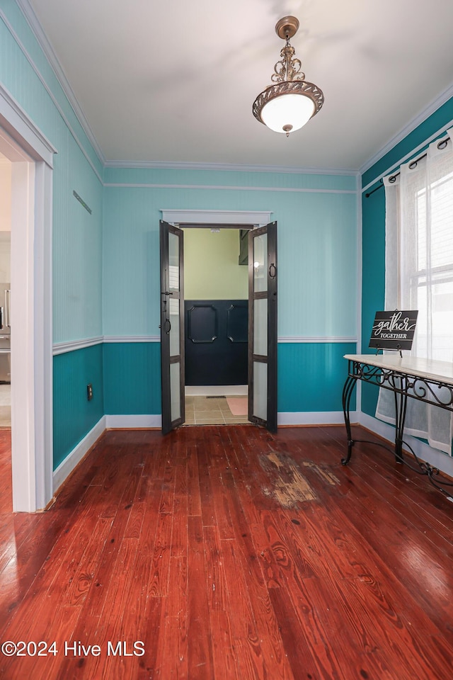 unfurnished room featuring wood-type flooring and ornamental molding