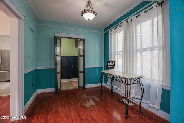 unfurnished dining area with crown molding and dark wood-type flooring