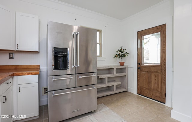 kitchen with white cabinetry, butcher block counters, stainless steel fridge with ice dispenser, and crown molding