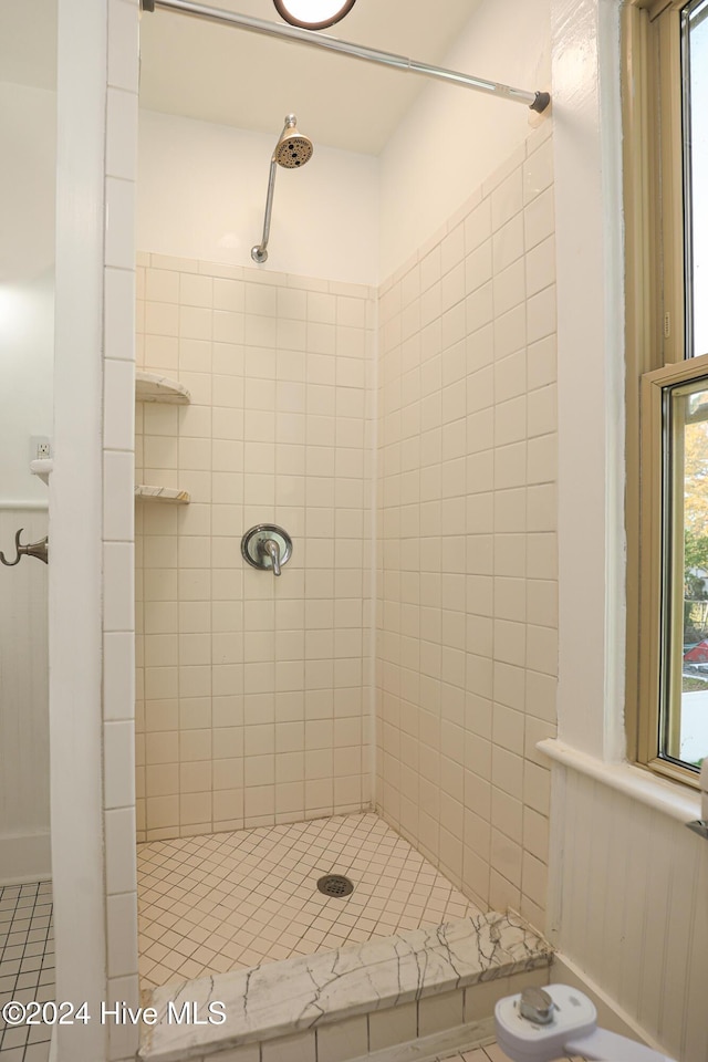 bathroom with tile patterned floors and tiled shower