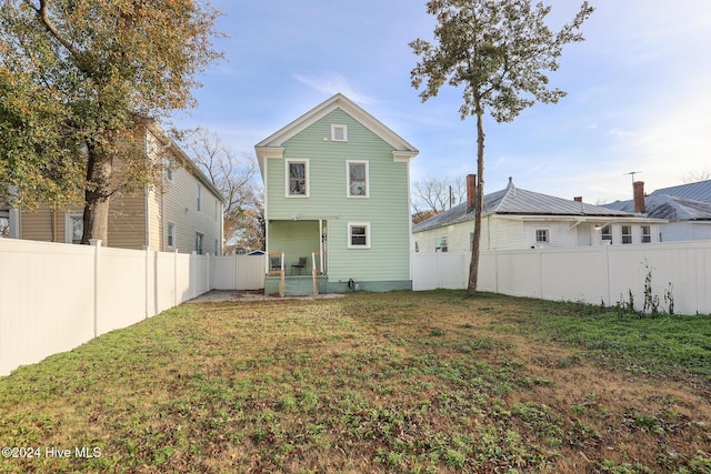 rear view of property with a lawn