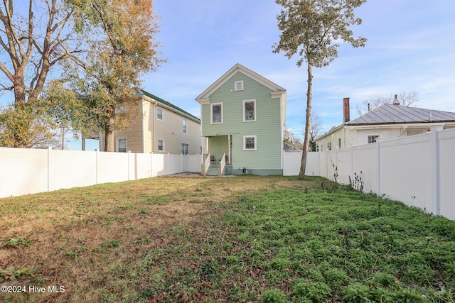 back of property featuring a lawn