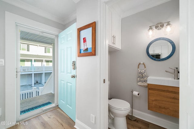 bathroom with vanity, hardwood / wood-style flooring, toilet, and crown molding