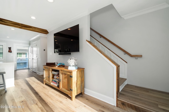 interior space with beam ceiling, crown molding, and hardwood / wood-style floors