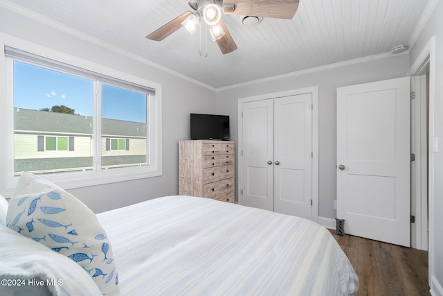 bedroom with ceiling fan, ornamental molding, dark wood-type flooring, and a closet