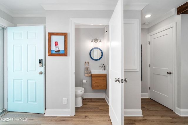 bathroom with hardwood / wood-style floors, vanity, toilet, and crown molding