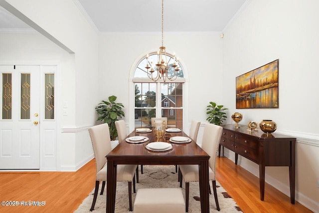 dining space with light wood-type flooring, baseboards, a chandelier, and ornamental molding