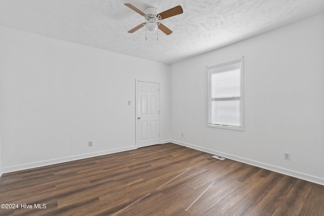 empty room with ceiling fan, dark hardwood / wood-style flooring, and a textured ceiling