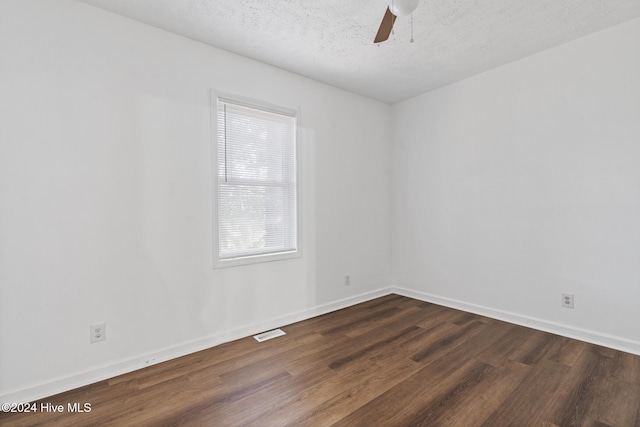 empty room with a textured ceiling, dark hardwood / wood-style floors, and ceiling fan