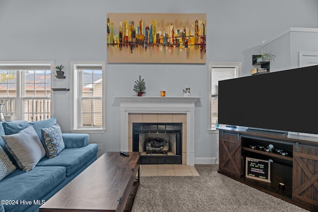 carpeted living room with a tile fireplace