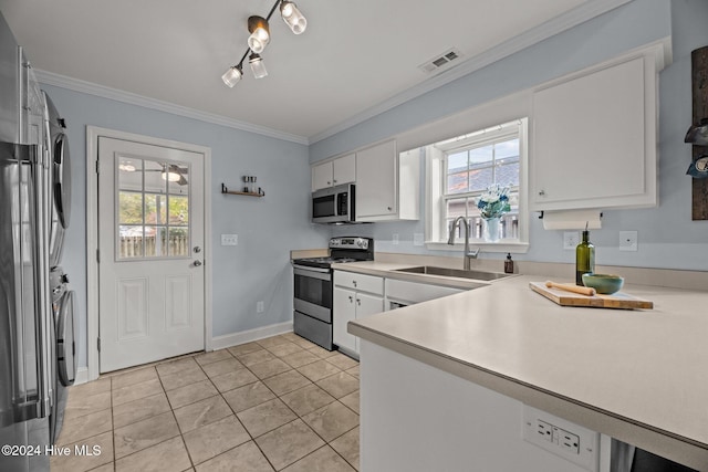 kitchen with stainless steel appliances, crown molding, sink, light tile patterned floors, and white cabinetry