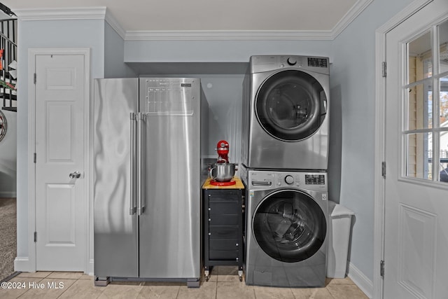 clothes washing area featuring light tile patterned floors, stacked washer and clothes dryer, and ornamental molding