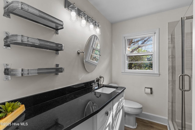 bathroom featuring vanity, hardwood / wood-style flooring, toilet, and walk in shower