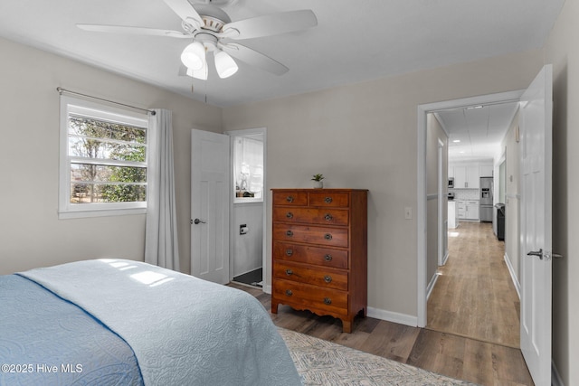 bedroom featuring ceiling fan, stainless steel fridge, and hardwood / wood-style floors