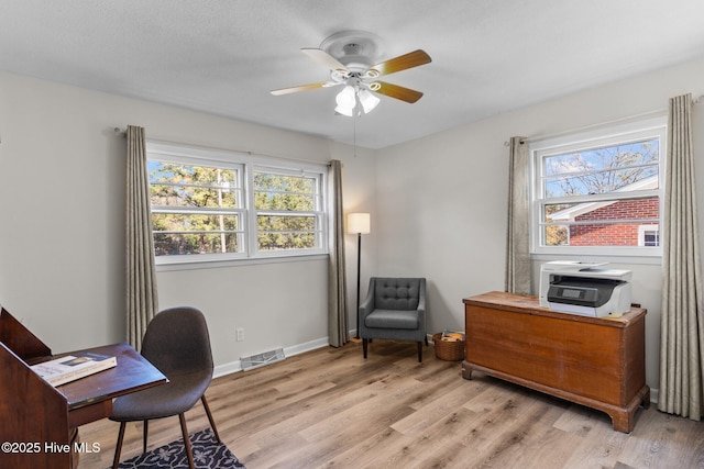 office with a wealth of natural light, ceiling fan, and light wood-type flooring