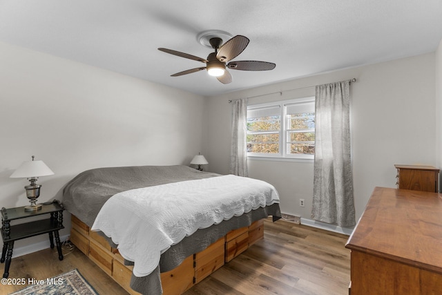 bedroom with dark wood-type flooring and ceiling fan