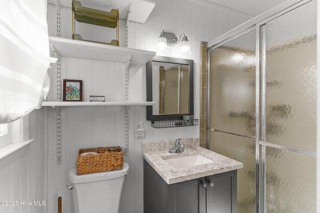 bathroom with vanity, a shower with shower door, and toilet