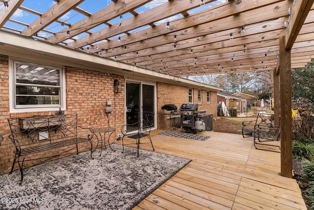 deck with a grill and a pergola