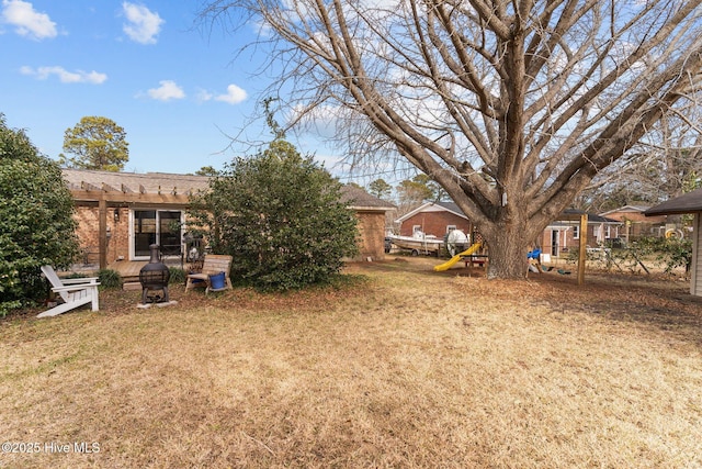 view of yard featuring a pergola and a playground