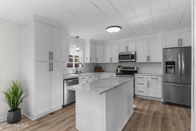 kitchen featuring white cabinetry, a kitchen island, wood-type flooring, and appliances with stainless steel finishes