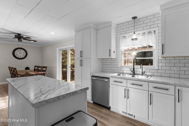 kitchen with sink, white cabinetry, decorative light fixtures, dishwasher, and hardwood / wood-style flooring