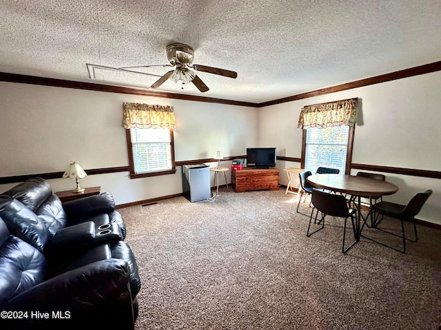 carpeted living room with ceiling fan, a textured ceiling, and ornamental molding