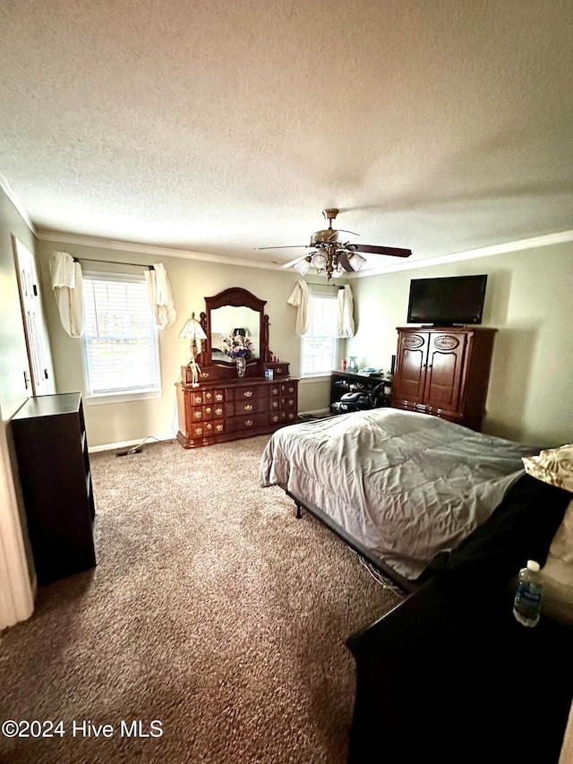 carpeted bedroom with ceiling fan, crown molding, and a textured ceiling