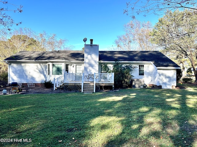 rear view of property with a wooden deck and a yard