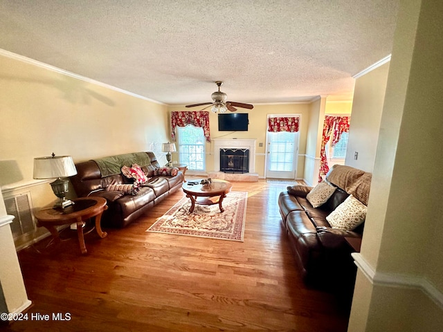 living room featuring hardwood / wood-style flooring, ornamental molding, and a textured ceiling