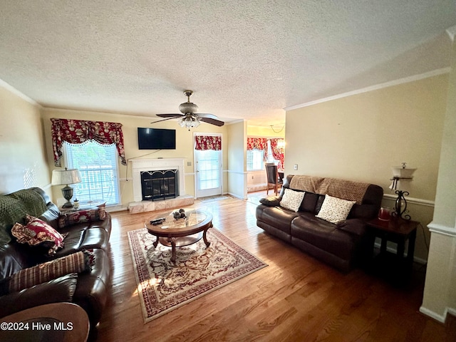 living room featuring crown molding, ceiling fan, a textured ceiling, and hardwood / wood-style flooring