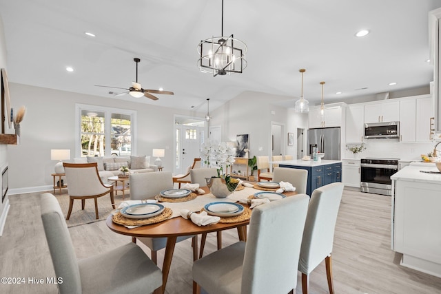 kitchen featuring blue cabinetry, appliances with stainless steel finishes, decorative light fixtures, and white cabinetry