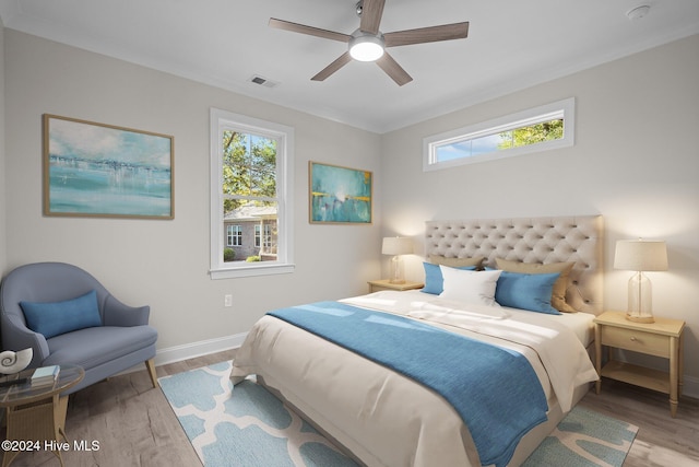 bedroom featuring light hardwood / wood-style flooring, ceiling fan, and crown molding