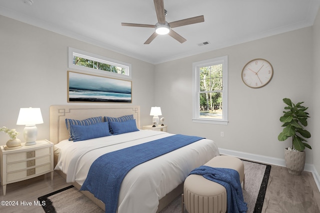 bedroom with hardwood / wood-style flooring, ceiling fan, and ornamental molding