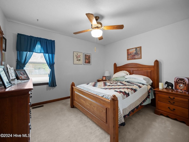 bedroom featuring light colored carpet and ceiling fan