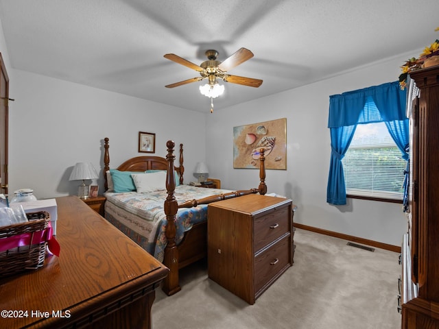 bedroom with light carpet, a textured ceiling, and ceiling fan