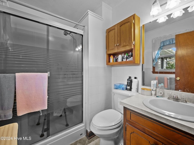 bathroom with vanity, tile walls, and toilet