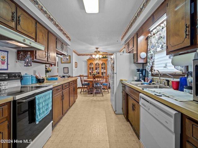 kitchen featuring a textured ceiling, ceiling fan, sink, and white appliances