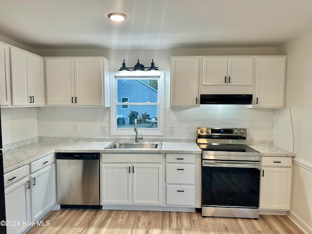 kitchen featuring sink, stainless steel appliances, white cabinetry, and exhaust hood