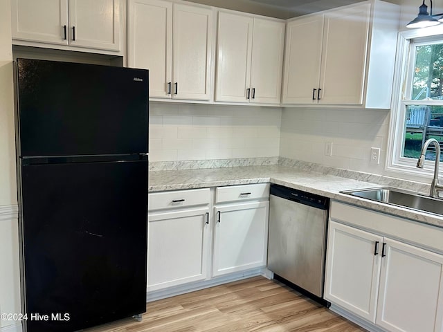 kitchen with dishwasher, black refrigerator, white cabinetry, and sink