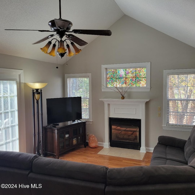 living room with ceiling fan, high vaulted ceiling, and light hardwood / wood-style floors