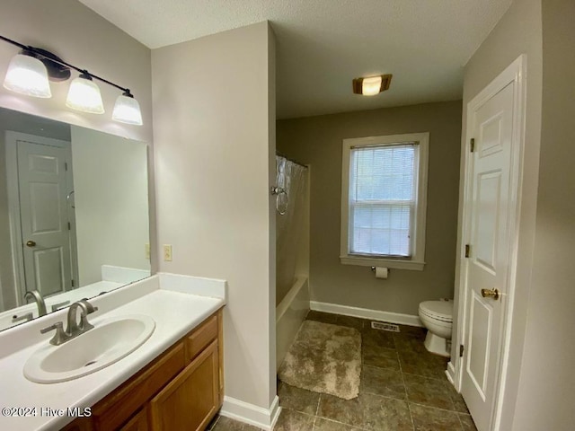 bathroom featuring a textured ceiling, vanity, and toilet