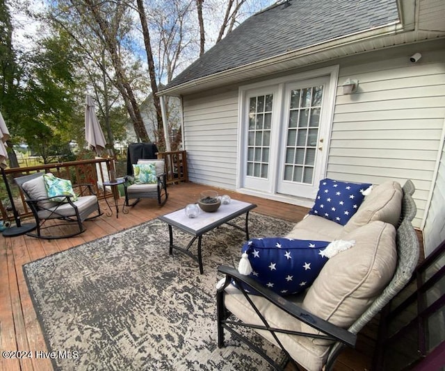 wooden terrace with an outdoor living space