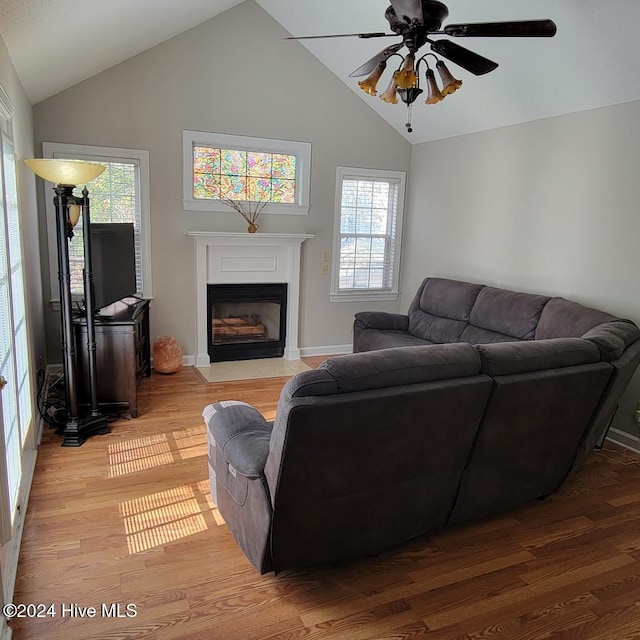 living room with ceiling fan, high vaulted ceiling, and light hardwood / wood-style flooring