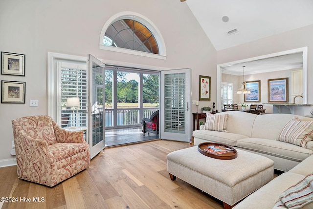 living room with high vaulted ceiling and light wood-type flooring