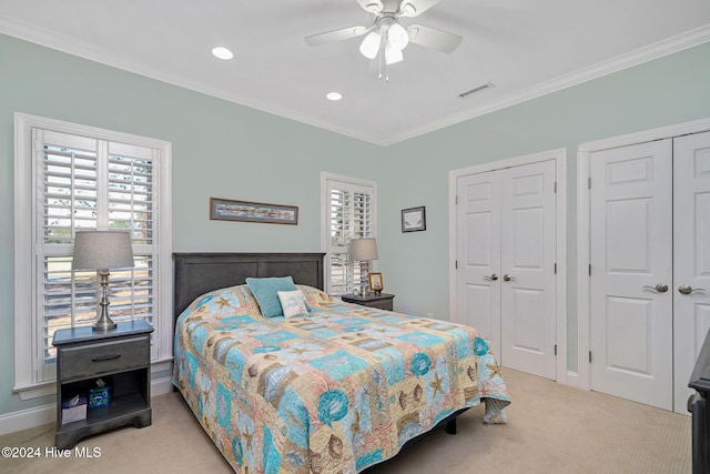 carpeted bedroom with ornamental molding and ceiling fan